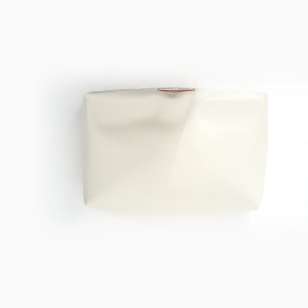 A cream faux-leather pouch, lifted out of the shell.